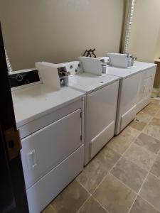 a group of white washers and dryers in a room at Westlake Inn in Strathmore