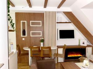 a living room with a table and a fireplace at MIR i LIRA apartmani Kopaonik in Kopaonik