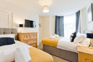 una camera da letto con due letti, una tv e una finestra di 5 Bed - 4 Doubles - Smart TVs - Contractor Base a Swansea