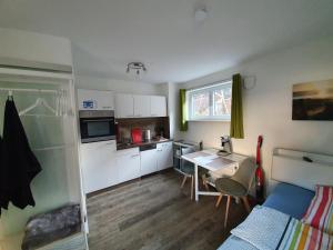 a small kitchen with a table and a bed in a room at Ferienwohnung Raiffeisenstraße - Obernburg in Obernburg am Main