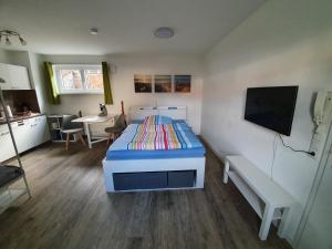 a bedroom with a bed and a table and a tv at Ferienwohnung Raiffeisenstraße - Obernburg in Obernburg am Main