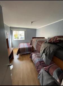 um quarto com três camas e uma janela em Apart Hotel Temuco em Temuco