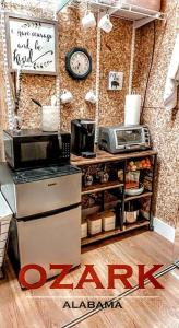 eine Küche mit einem Herd und einer Mikrowelle an der Wand in der Unterkunft Cozy, Cute, Private Ozark Suite 5 Mins to Hospital in Ozark