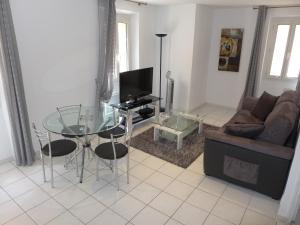 ein Wohnzimmer mit einem Glastisch und einem Sofa in der Unterkunft Central 1 bedroom Riouffe 2 mins from the Palais and Croisette 206 in Cannes