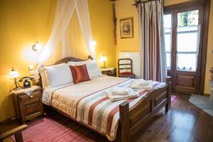 a bedroom with a large bed and a window at Archontiko Tsiboni in Elati Trikalon