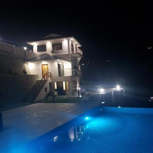 a house at night with a swimming pool in front of it at Maison L'Horizon in De Quincey Village