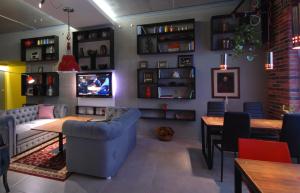 Cubby Hotel في إلفيف: غرفة معيشة مع أريكة زرقاء وتلفزيون