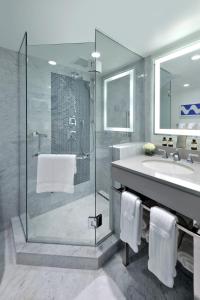 uma casa de banho com uma cabina de duche em vidro e um lavatório. em Hamilton Princess & Beach Club A Fairmont Managed Hotel em Hamilton
