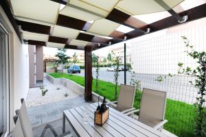 a patio with a wooden table and chairs on a patio at Apartments Hills in Zadar