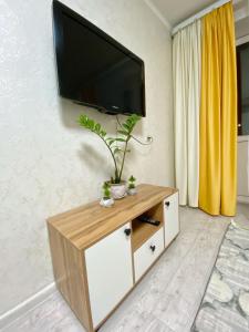 a living room with a flat screen tv on a wall at Апартаменты на Ахметова 6 in (( Turksib ))