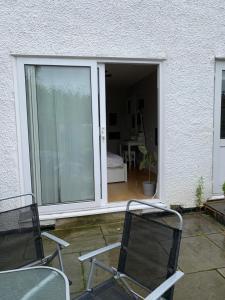 two chairs sitting on a patio with a sliding glass door at Immaculate 4 bedroom house Near central London in Edgware