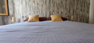a large white bed with two pillows on it at Apartamentos Pou, bloque con tres apartamentos independientes, reformados, confortables, y a la playa andando in Villajoyosa
