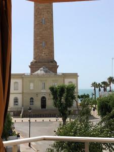 a building with a clock tower in front of it at Remarkable 3-Bed Apartment in Chipiona in Chipiona