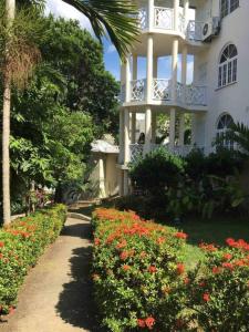 a white building with a walkway in front of flowers at Immaculate 1-Bed Villa in Ocho Rios in Ocho Rios +22 photos