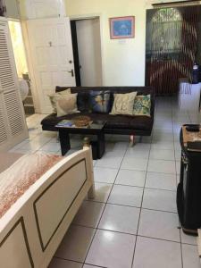 a living room with a couch and a coffee table at 1 Bed Villa - Sleeps 2 - Garden - Parking - Wifi in Ocho Rios