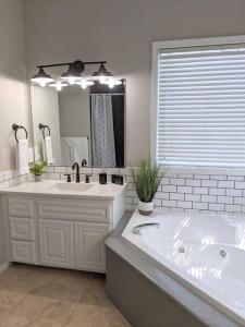 a bathroom with a large tub and a large mirror at Meridian BnB ID - Pristine 4BR 2BA Spacious Home In The Heart Of Meridian Near Boise in Meridian