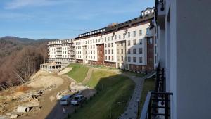 a large building with cars parked in front of it at SkyKop Apartman L21 in Kopaonik