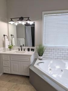 a bathroom with a large tub and a large mirror at Meridian BnB ID - Pristine 4BR 2BA Spacious Home In The Heart Of Meridian Near Boise in Meridian
