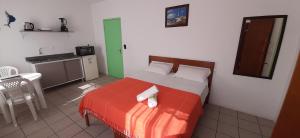 a small bedroom with a bed with a red blanket at Pousada Milani in Florianópolis