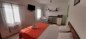 a bedroom with a bed with an orange blanket at Pousada Milani in Florianópolis
