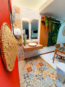 a bathroom with a sink and a mirror at Pousada Quaraçá Maceió Pajuçara in Maceió