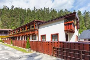 a house with a wooden fence in front of it at Penzion Sabina in Vernár