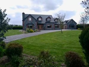 una grande casa in mattoni con un ampio cortile di Carraig House Cozy countryside apartment a Cavan