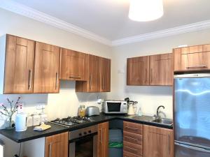 una cucina con mobili in legno e un forno a piano cottura di Carraig House Cozy countryside apartment a Cavan
