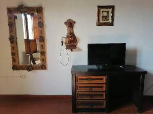 a television on a dresser in a room with a mirror at Suites de Lujo en el Corazón de la ciudad in Guanajuato