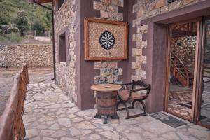 a stone building with a table and a wheel on the wall at oneiropagidasuites in Kalavrita