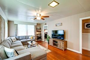uma sala de estar com um sofá e uma televisão de ecrã plano em Hale Leilani - Hilo 3BR cold AC em Hilo
