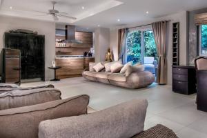 a living room with two couches and a kitchen at Villa BanRomYen 50AB SiamRoyalView 70mtrs to Beach in Ko Chang