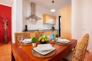 a kitchen with a wooden table with a bowl of fruit at Villa Jesús Lanzarote-Papagayo in Yaiza +12 photos