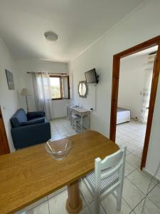 a living room with a table and a blue couch at Irene Komos in Pitsidia