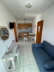 a living room with a blue couch and a table at Irene Komos in Pitsidia