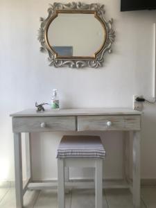 a dressing table with a mirror and a stool at Irene Komos in Pitsidia