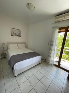 a bedroom with a bed and a tiled floor at Irene Komos in Pitsidia