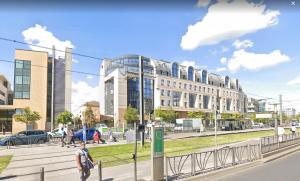 Ein Mann, der eine Straße entlang geht, neben einem Gebäude in der Unterkunft Superbe appartement à La Garenne Colombes in La Garenne-Colombes