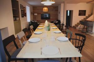 een lange tafel met borden en glazen erop bij Les Briquettes in Mailly-Champagne