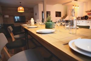 a wooden table with wine glasses and a bottle on it at Les Briquettes in Mailly-Champagne