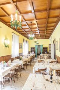 ein Esszimmer mit weißen Tischen und Stühlen in der Unterkunft Hotel Ristorante San Carlo in Salsomaggiore Terme
