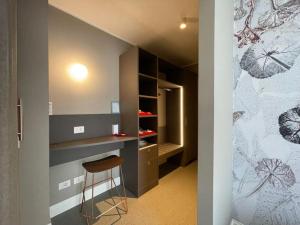 a kitchen with a counter and a stool in a room at Anjoy&Bleev Rooms in Rho