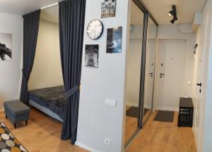 een kamer met een spiegel en een klok aan een muur bij Studija Alytuje in Alytus