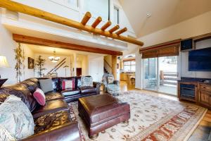 a living room with a leather couch and a table at Saddle Ridge Townhome I-5 in Big Sky
