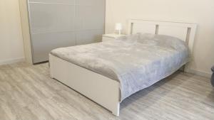 een wit bed in een witte kamer met een matras bij Апартаменты на первой линии до моря 50 метров in Novorossiejsk