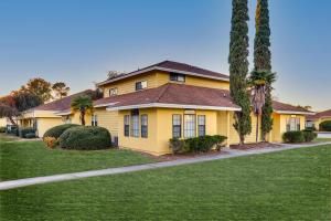a yellow house with palm trees in front of it at Mariners Suites - Kingsland in Kingsland