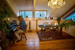 a man playing the piano in a living room at Romantic Spa Villa with Fireplace by the lake in Stjärnsund