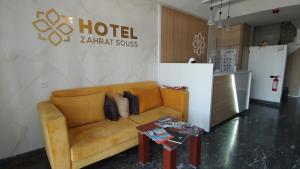 a living room with a couch and a table at Hôtel Zahrat Souss -Inezgane in Inezgane