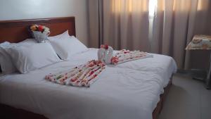 een wit bed met een paar handdoeken erop bij Hôtel Zahrat Souss -Inezgane in Inezgane