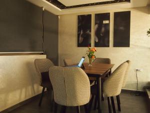 a dining room with a table and chairs with a laptop at Hôtel Zahrat Souss -Inezgane in Inezgane